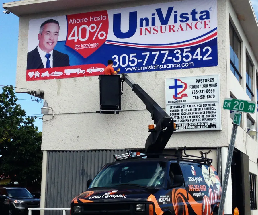 Crew on a bucket truck installing a Univista Insurance sign